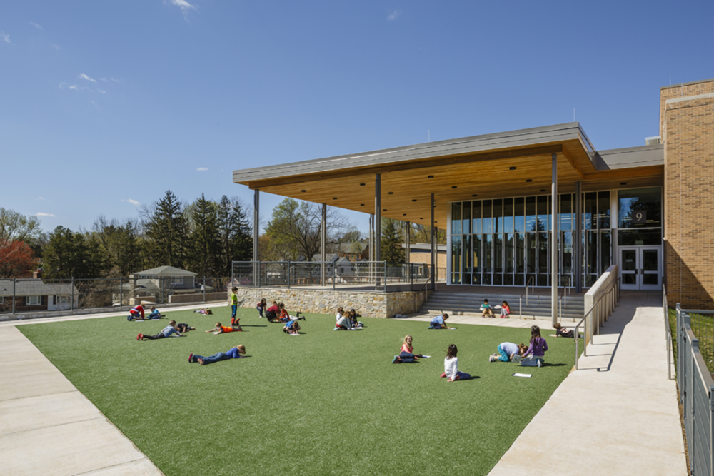 Zero Energy and 100% welcoming, Discovery Elementary School’s public spaces are defined by a large roof canopy with a cedar soffit that serves as a front porch and support to the solar panels above. Image by Lincoln Barbour, courtesy of Discovery Elementary.